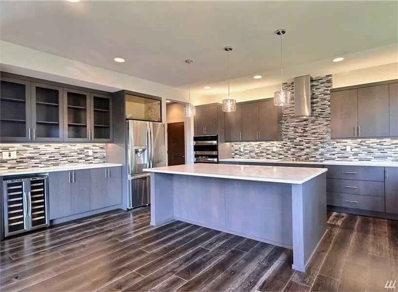 Kitchen with gray cabinetry, a wine fridge, and a center island.