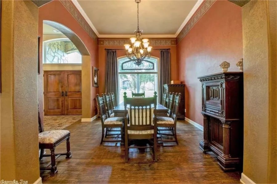 Dining room with a dark wood dining set huge windows overlooking the courtyard.