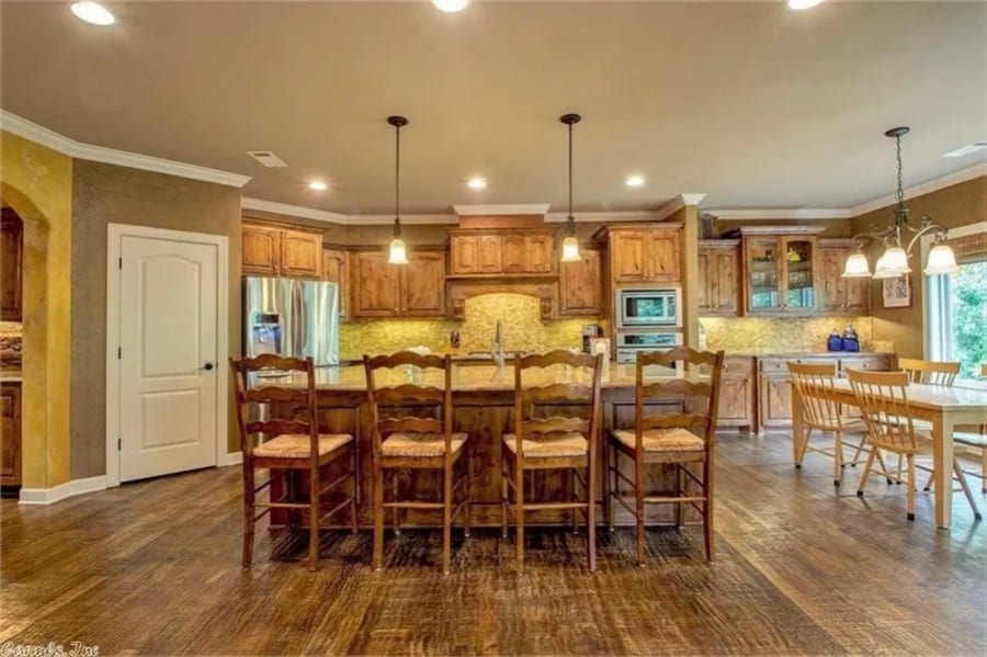 Kitchen with a breakfast island and a corner pantry concealed behind the white door.