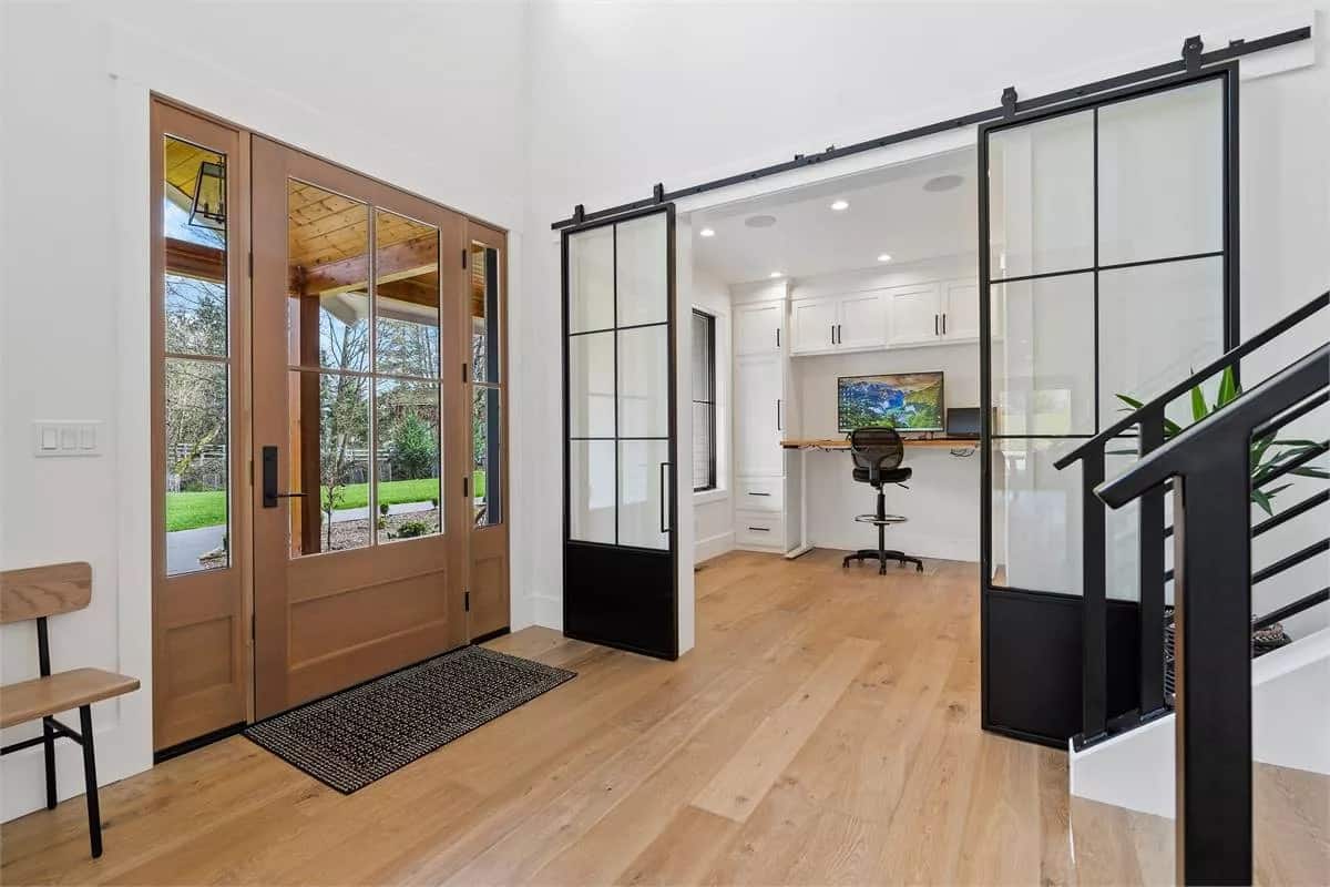 Foyer with a glazed front door and sliding barn doors that reveal the office.