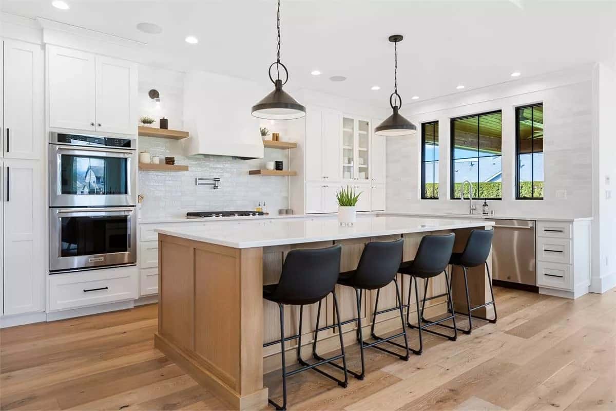 Kitchen with white cabinetry and a breakfast island with seating for four.