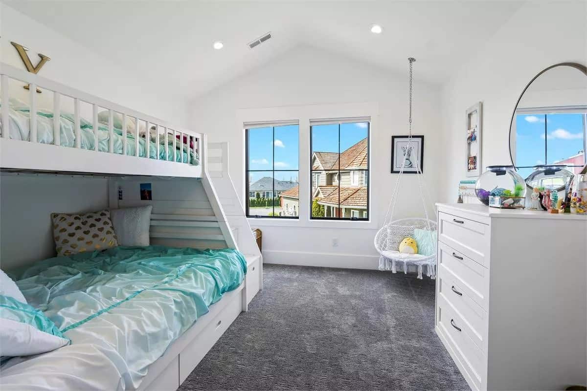 Bedroom with a bunk bed, a swinging chair, and a white dresser over the carpeted flooring.