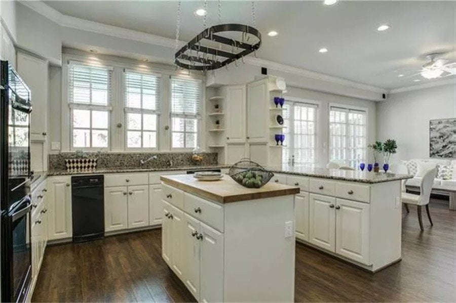 Kitchen with white cabinets, granite countertops, and a center island.