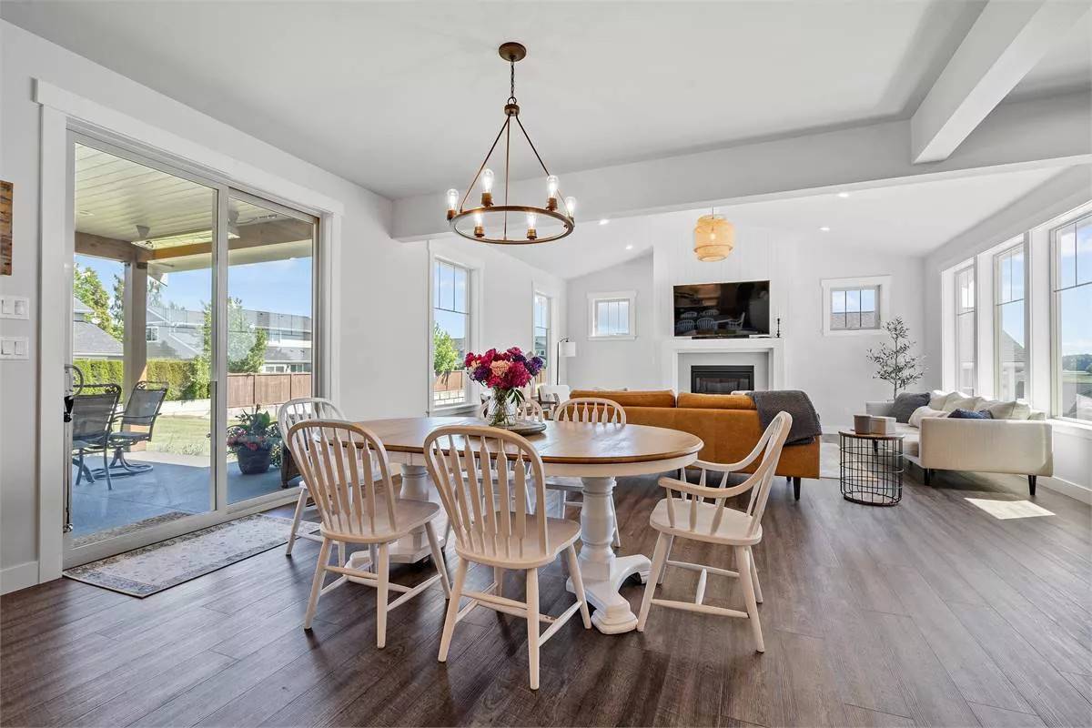 Dining area with an oval dining set and sliding doors that open onto a covered patio.