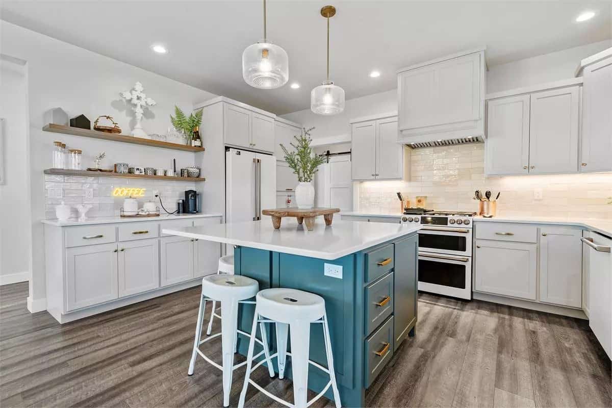 The kitchen includes floating shelves and a center island with casual seating.