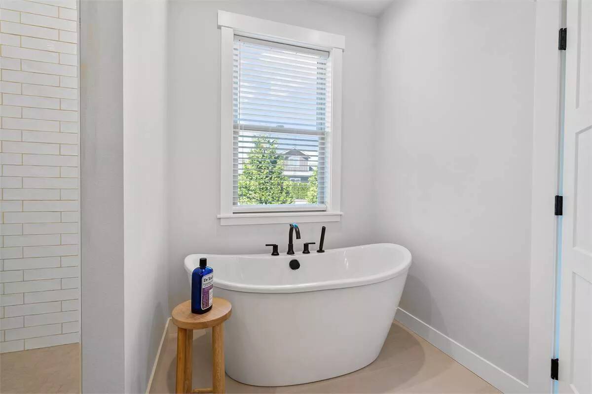 The primary bathroom includes a soaking tub and a tiled shower.