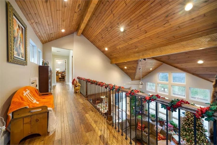 Second-level balcony with hardwood flooring and wrought iron railing.