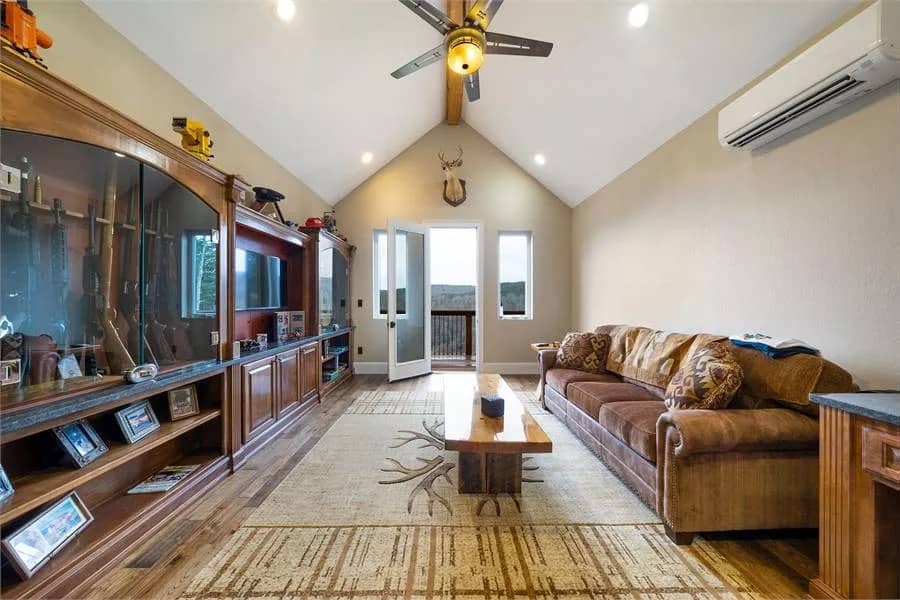 Bonus room with a sectional sofa, built-in cabinets, and a cathedral ceiling lined with an exposed beam.