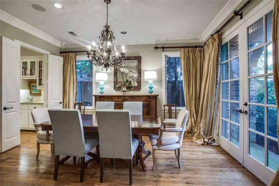 Dining room with an oval dining set, a matching buffet table, and front porch access via a French door.