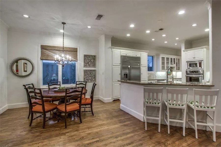 Breakfast nook with a round dining table surrounded by cushioned chairs.