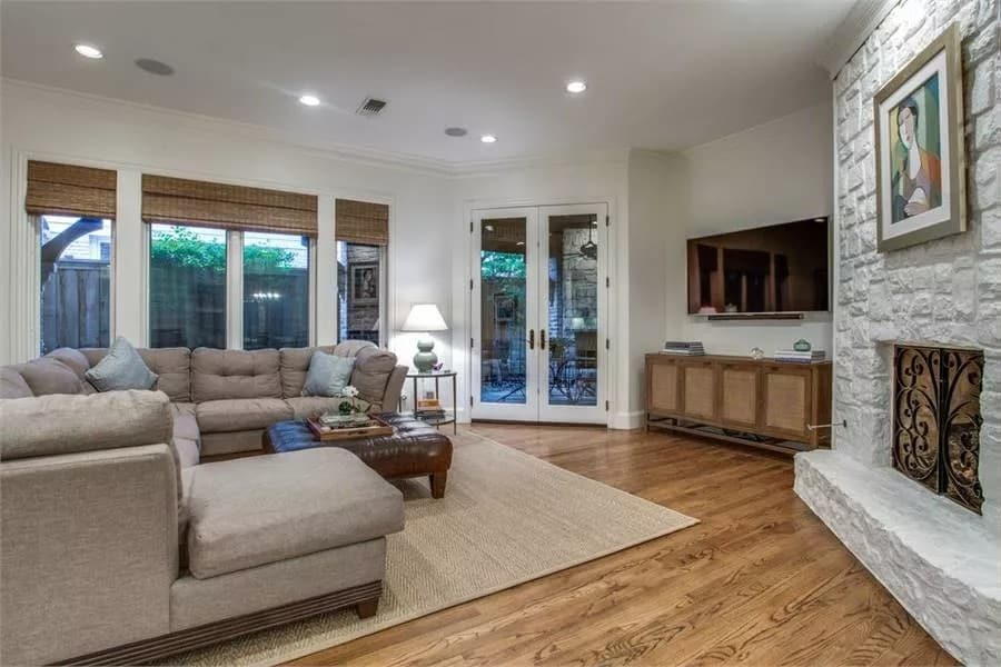 The family room includes a stone fireplace and a wall-mounted TV.