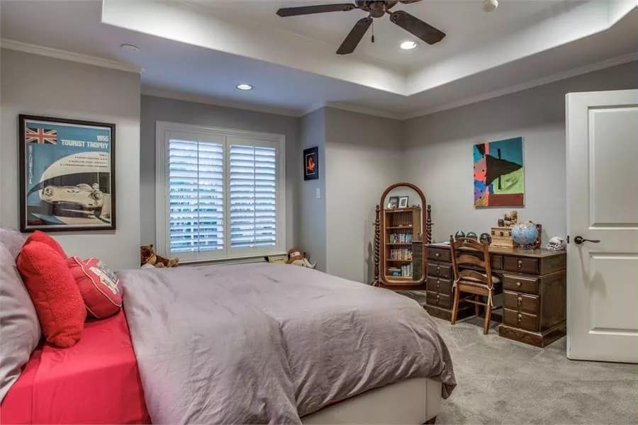 Bedroom with louvered windows, a wooden desk and a full-length mirror.