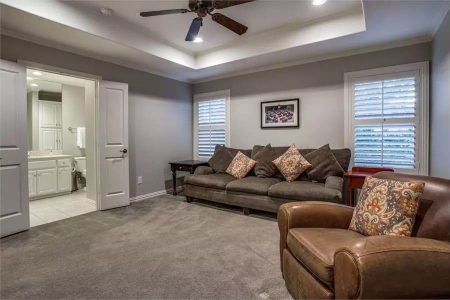 Media room with a sectional sofa, a leather chair, and an ensuite bath with double doors.
