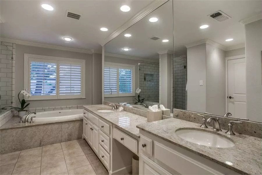 Primary bathroom with a drop-in tub, a tiled shower, and a dual sink vanity with a makeup counter.
