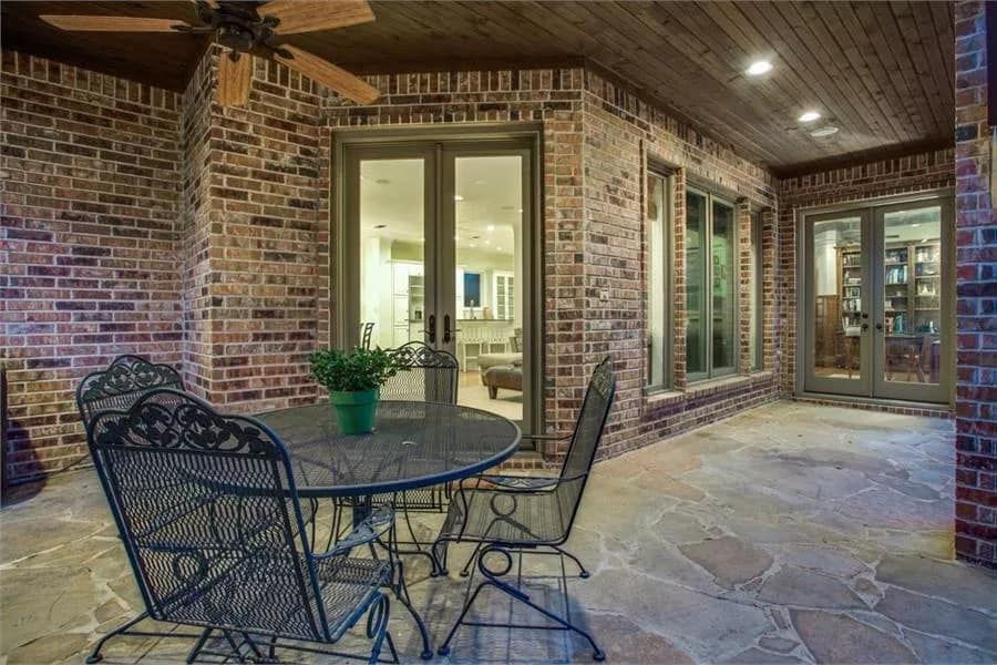 Outdoor living with a perforated round dining set over the flagstone flooring.