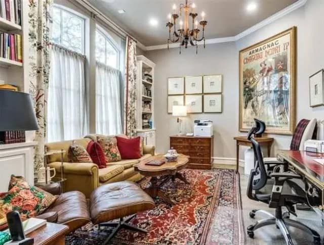 Study with a taupe sofa, a leather lounge chair, and a wooden coffee table over the vintage area rug.