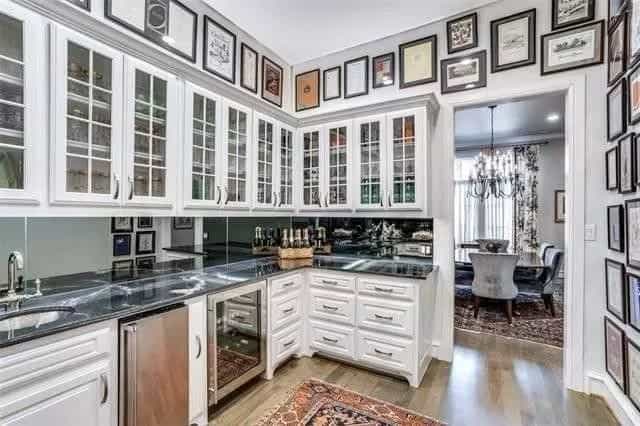 Butler's pantry with glass-front cabinets, a wine fridge, and a prep sink.