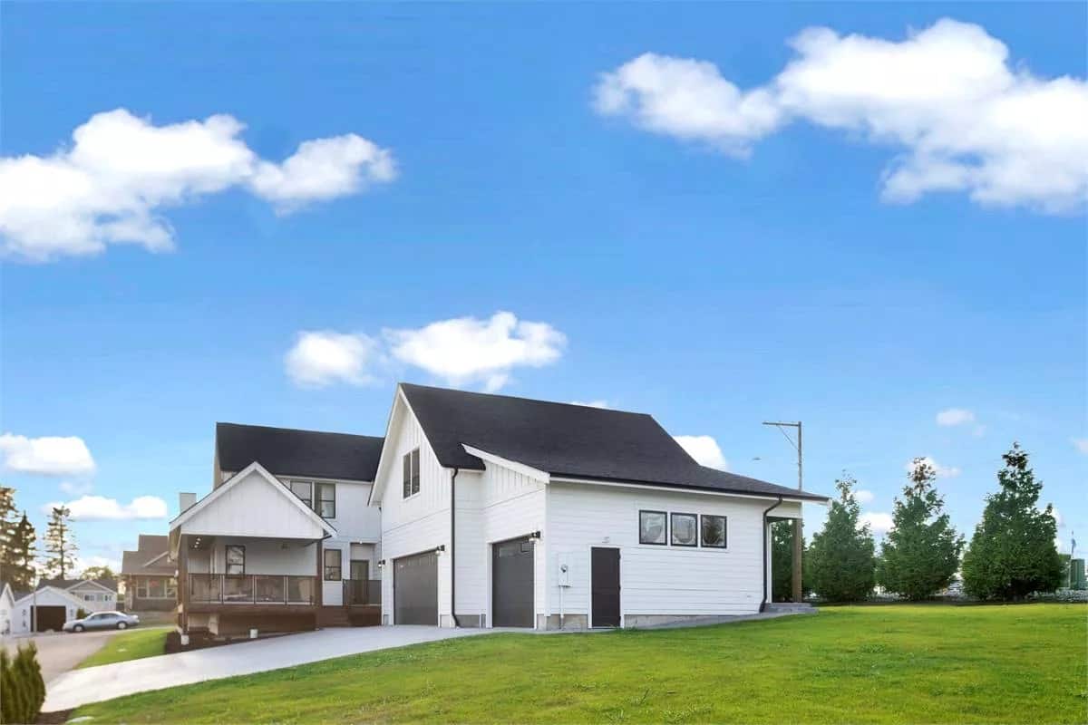 Front-right view showcasing the 3-car garage with a man door on the side.
