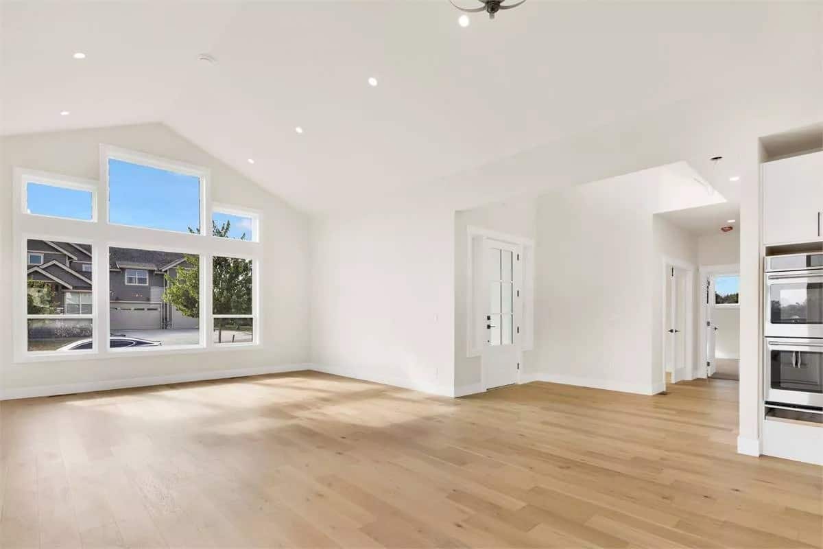 Great room and dining area with a wall of windows and a vaulted ceiling.