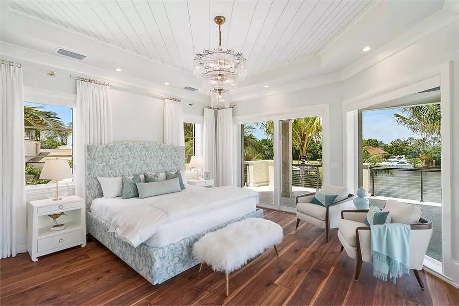 Guest suite with a tray ceiling, hardwood flooring, and a private balcony.