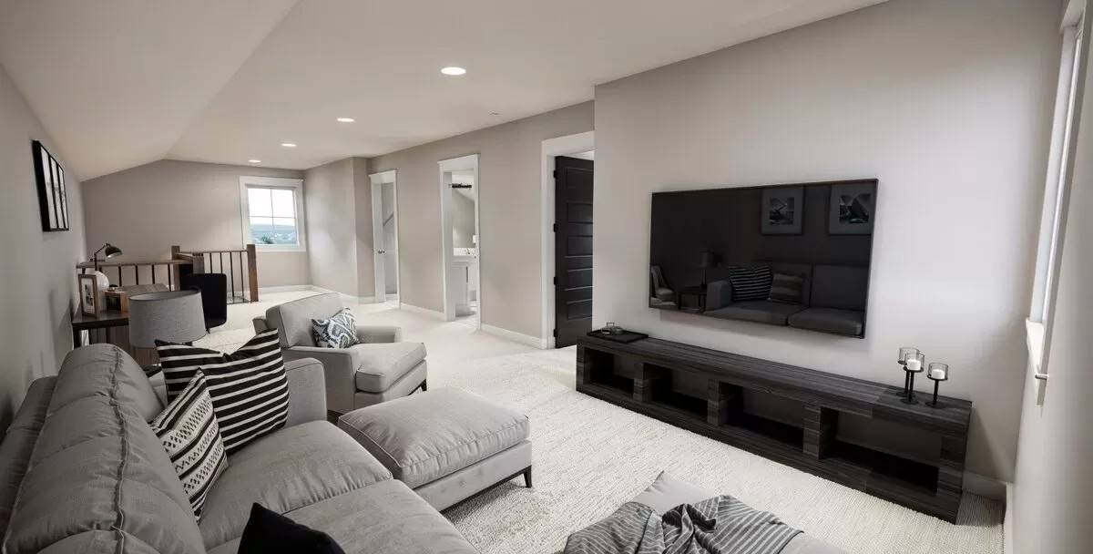 Loft with a sectional sofa and a wall-mounted TV under the vaulted ceiling.