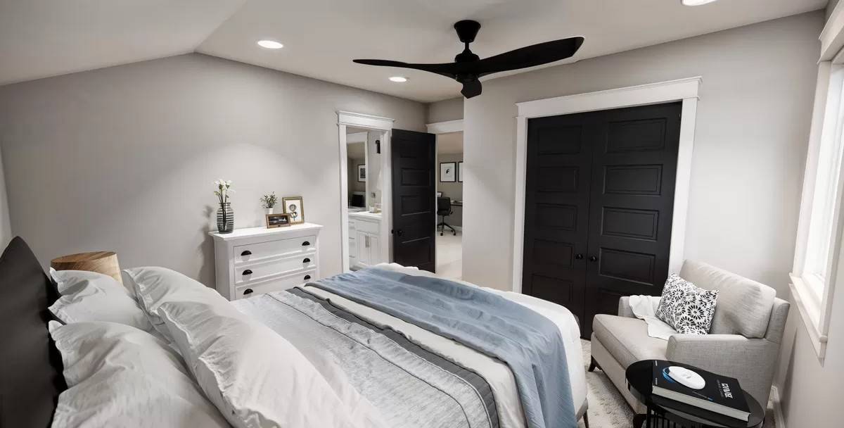 Secondary bedroom with a cushioned armchair and a built-in wardrobe hidden behind the double doors.