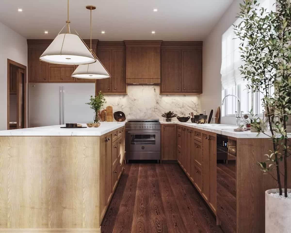 The kitchen includes stainless steel appliances and a breakfast island illuminated by dome pendants.