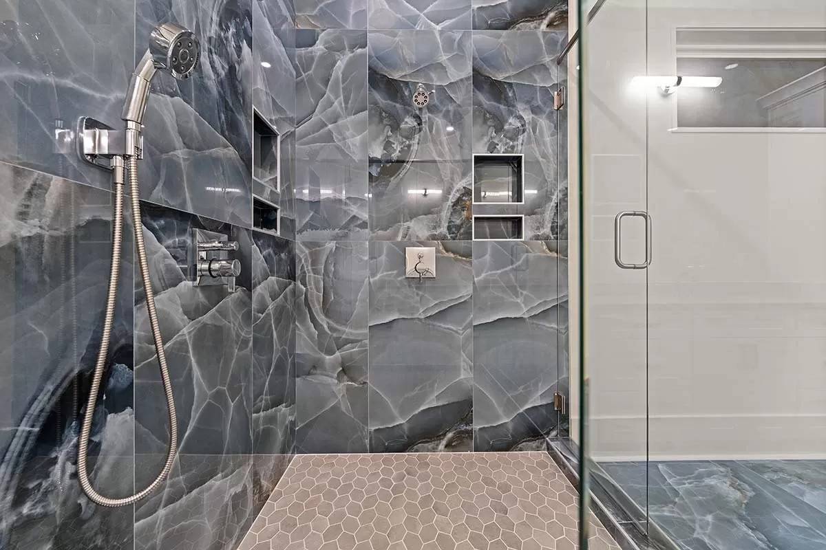 Primary bathroom with slate marble walls and hex-tiled flooring.