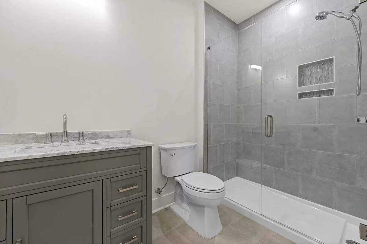 Bathroom with a sink vanity, a toilet, and a walk-in shower.