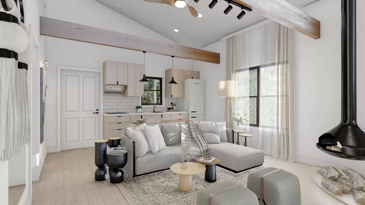 Living room and kitchen with a wood stove, an L-shaped sofa, and light wood cabinets.