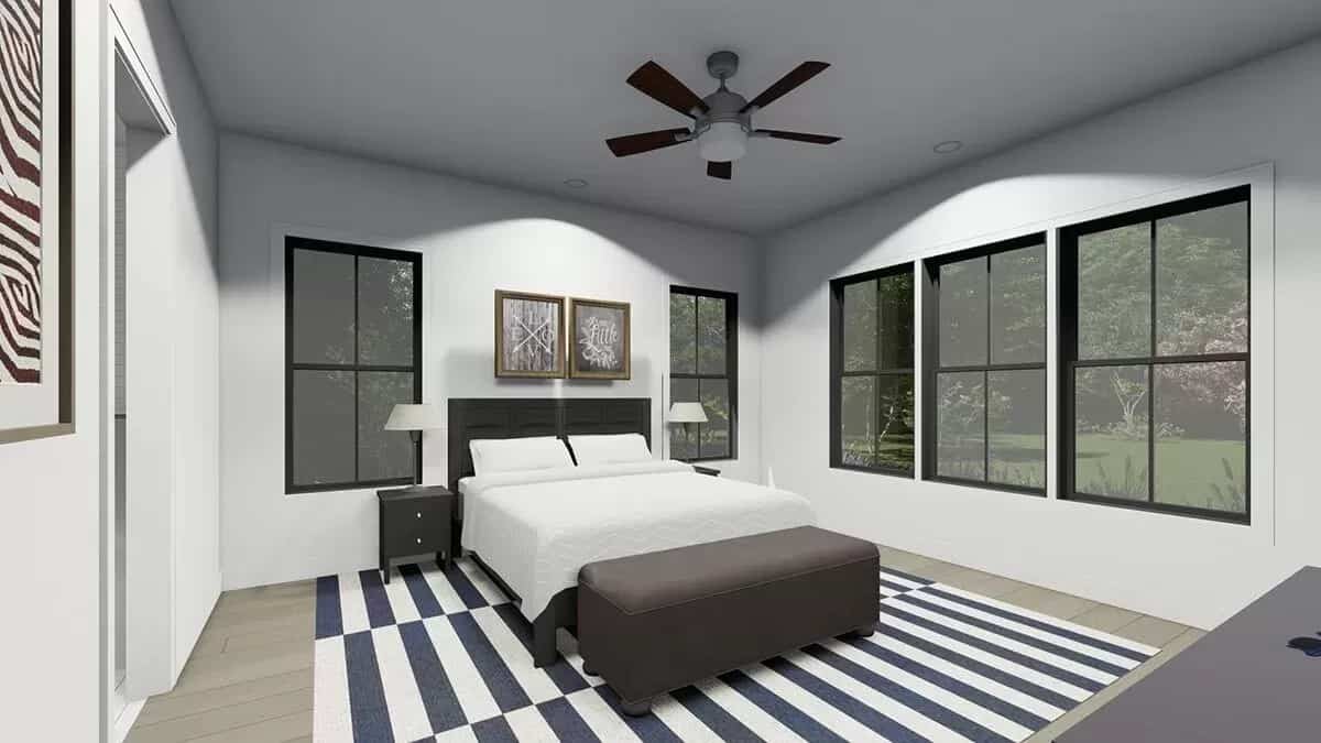 Primary bedroom with a dark wood bed and a storage bench over the striped area rug.