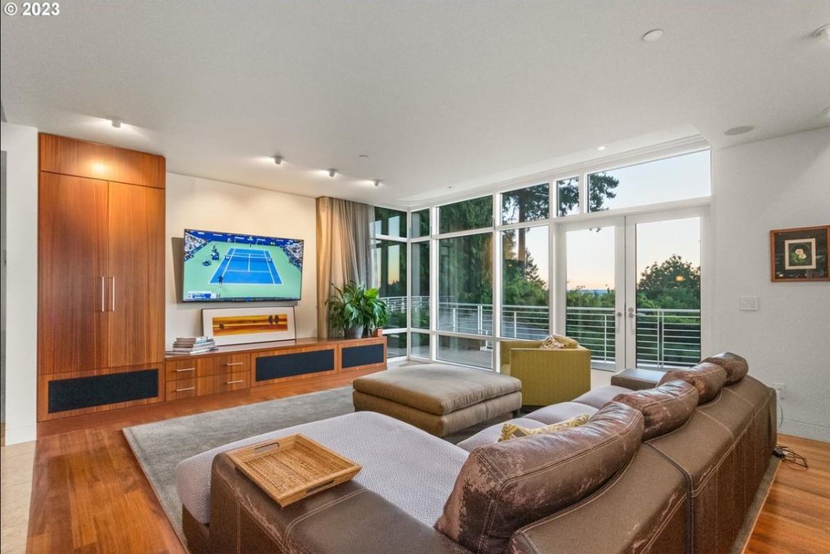 Living room with a TV, couch and glass doors.