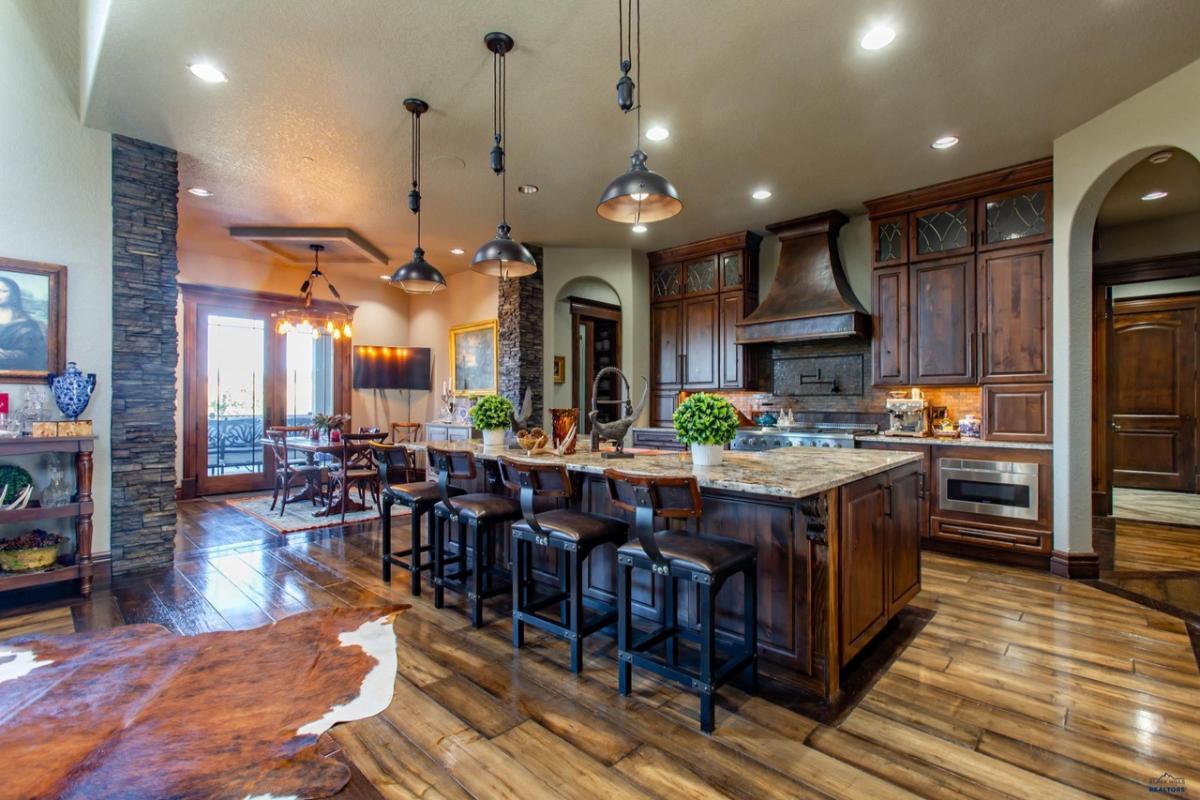 Kitchen with a large island, custom lights and custom cabinets.