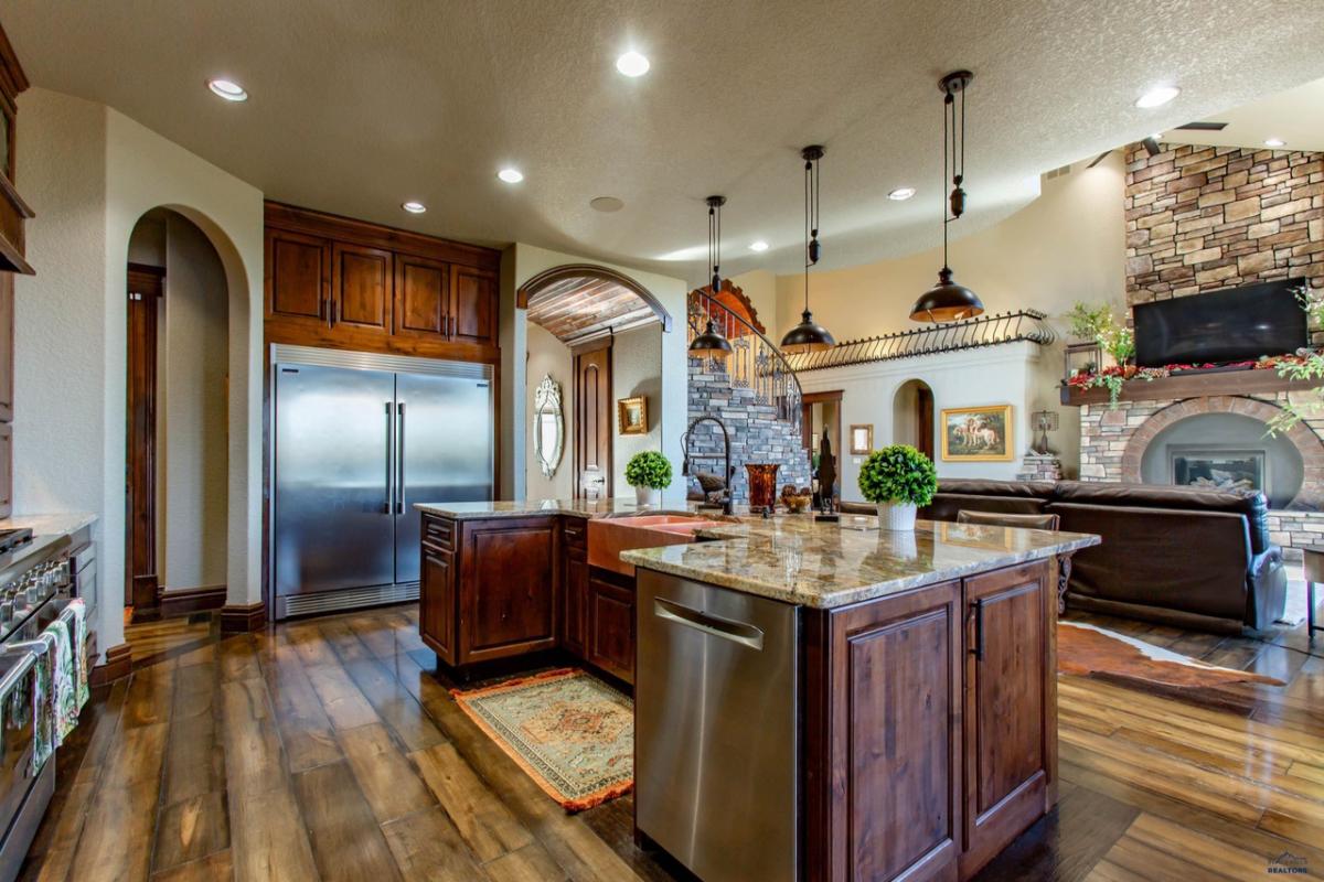 Kitchen with a large island, custom lights and custom cabinets.