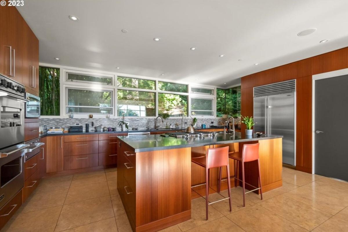 Kitchen with a large island, custom lights and custom cabinets.