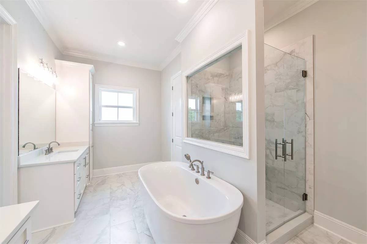 Primary bathroom with his and her vanities, a soaking tub, and a walk-in shower.