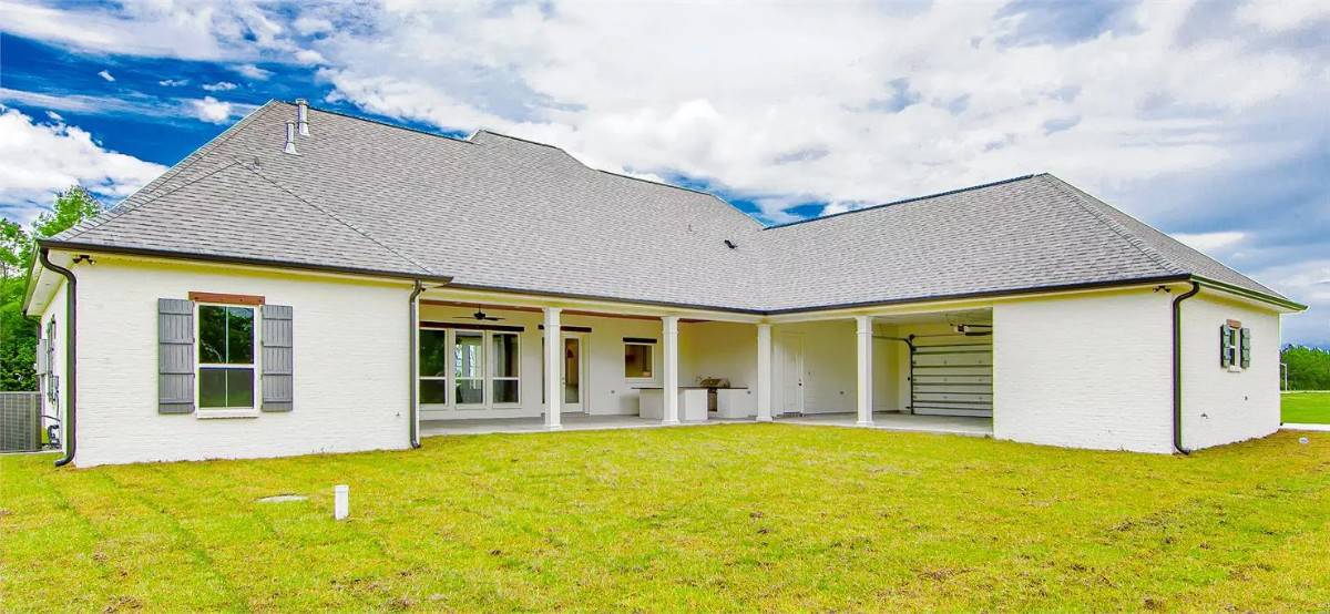 Rear view showcasing the covered porch and garage.