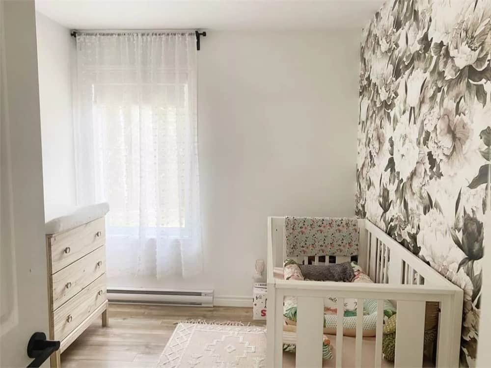 Nursery room with white furnishings over the hardwood floor.