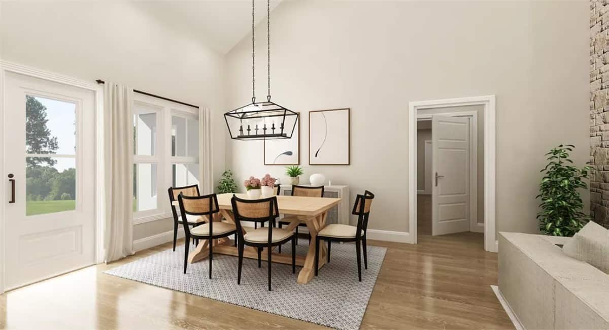 Dining room with a linear chandelier and a wooden dining set over the gray area rug.