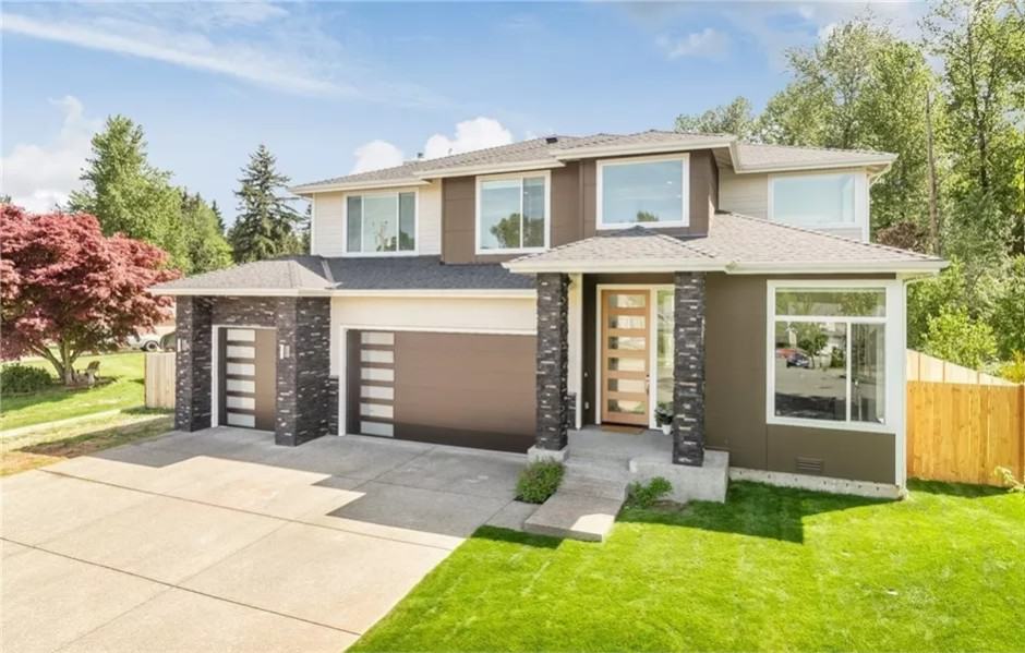 Front view with a covered entry and a 3-car garage.