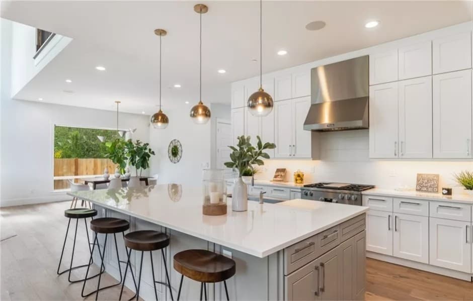 The kitchen includes white cabinets and stainless steel appliances.