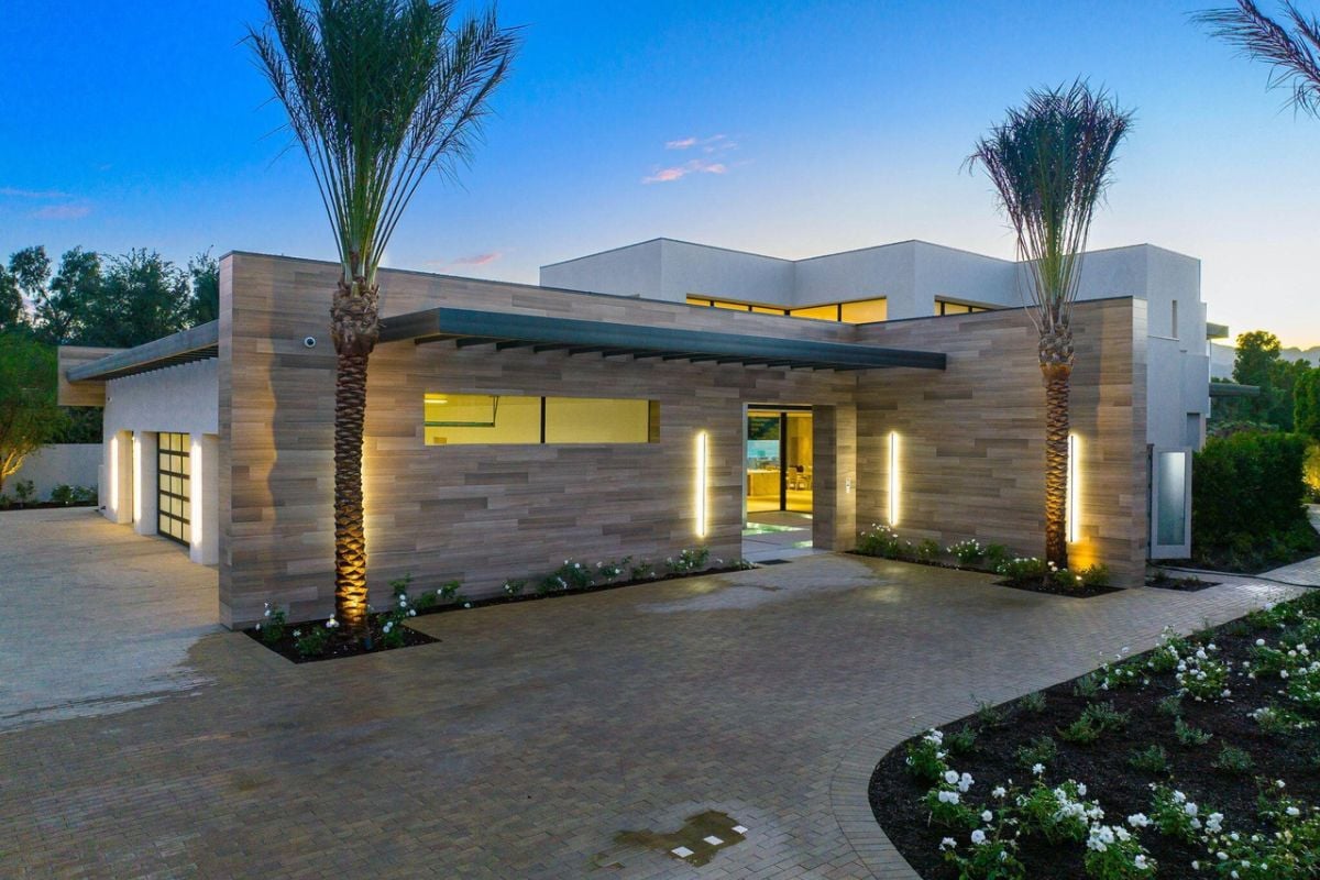 A brick courtyard adorned with palm trees and bushes.