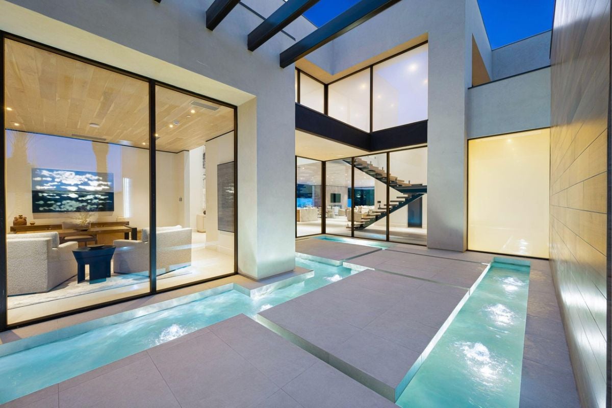 A tiled walkway bordered by the water from the swimming pool.