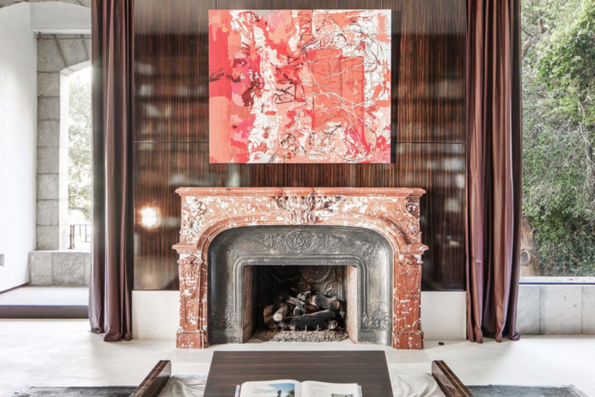 A fireplace with a painting on top.