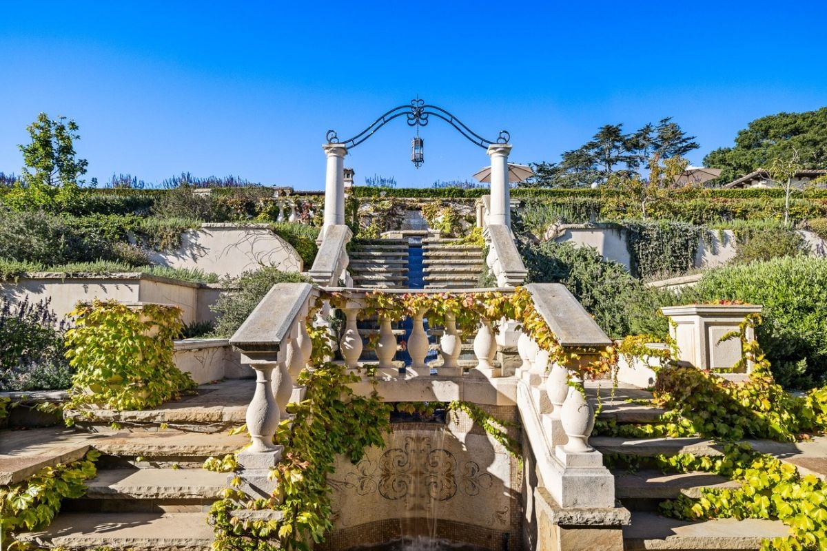 An outdoor stone staircase surrounded by lots of plants.