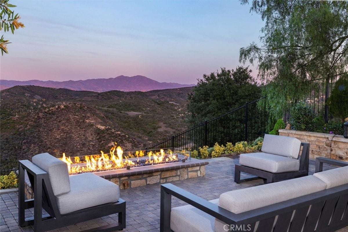 An outdoor fire pit with couches and chairs.