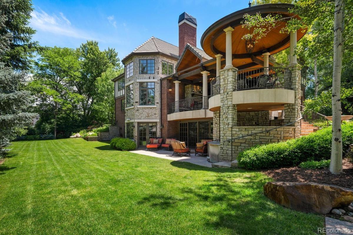 Exterior view of the real estate with a large green lawn.
