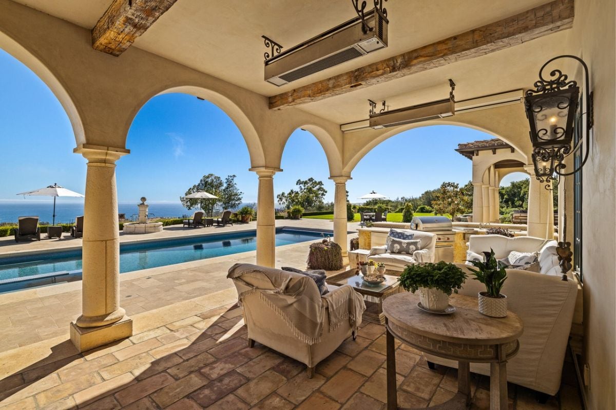 An outdoor living space with a couch, chairs, and a center table.