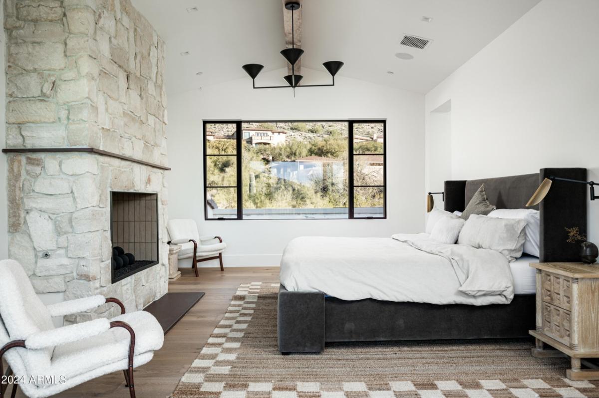 Bedroom with a large bed, glass windows and large rug.