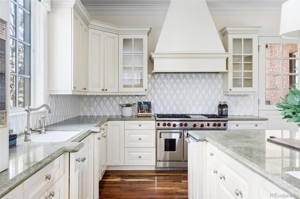 Kitchen with a large island, glass windows and a stove.
